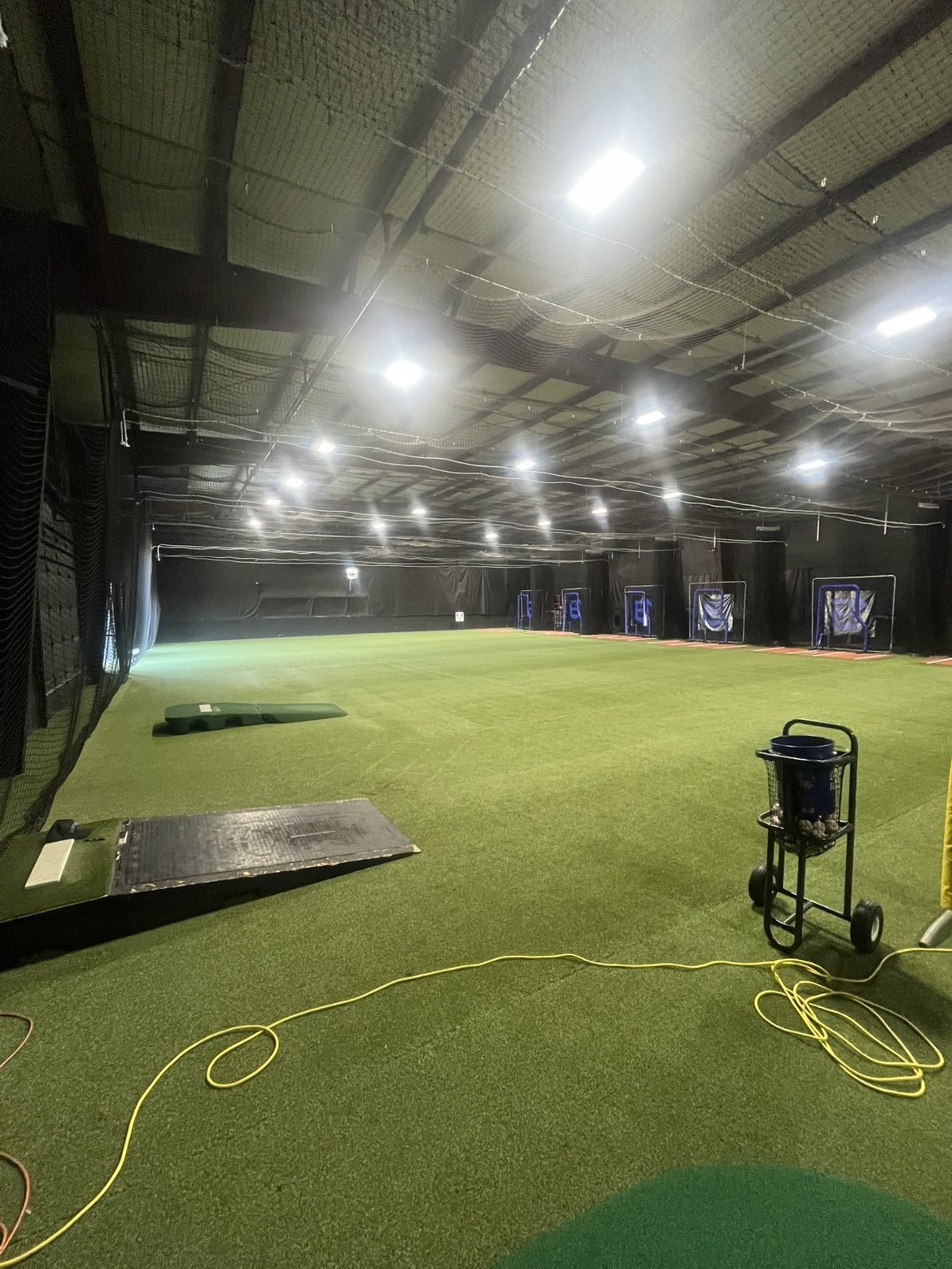 Indoor turf area with pitching mounds and batting cages